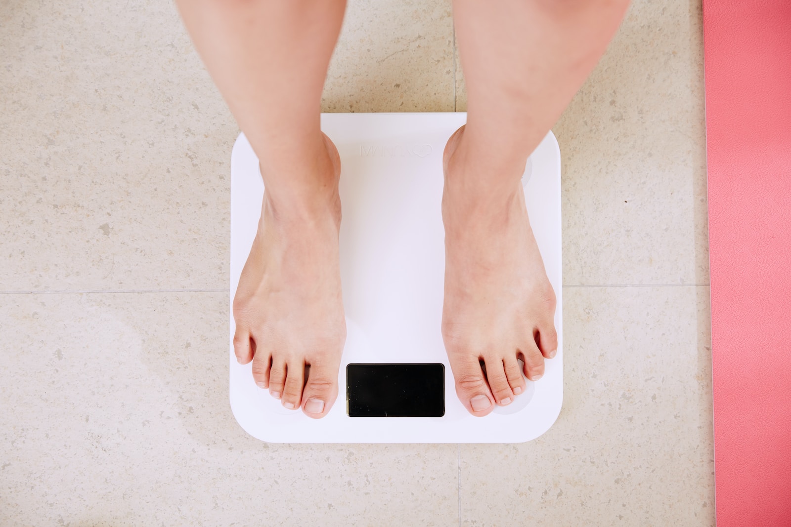 Person standing on white digital bathroom scale