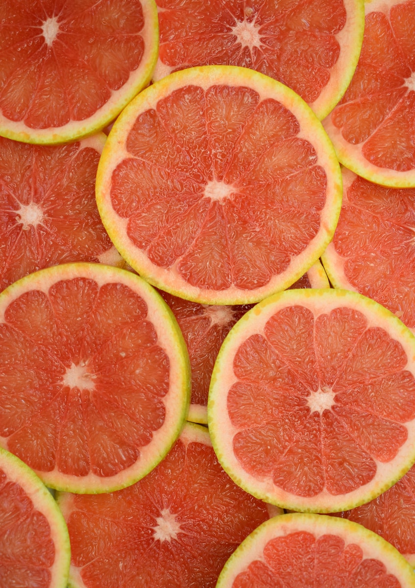 Sliced orange fruit on red surface