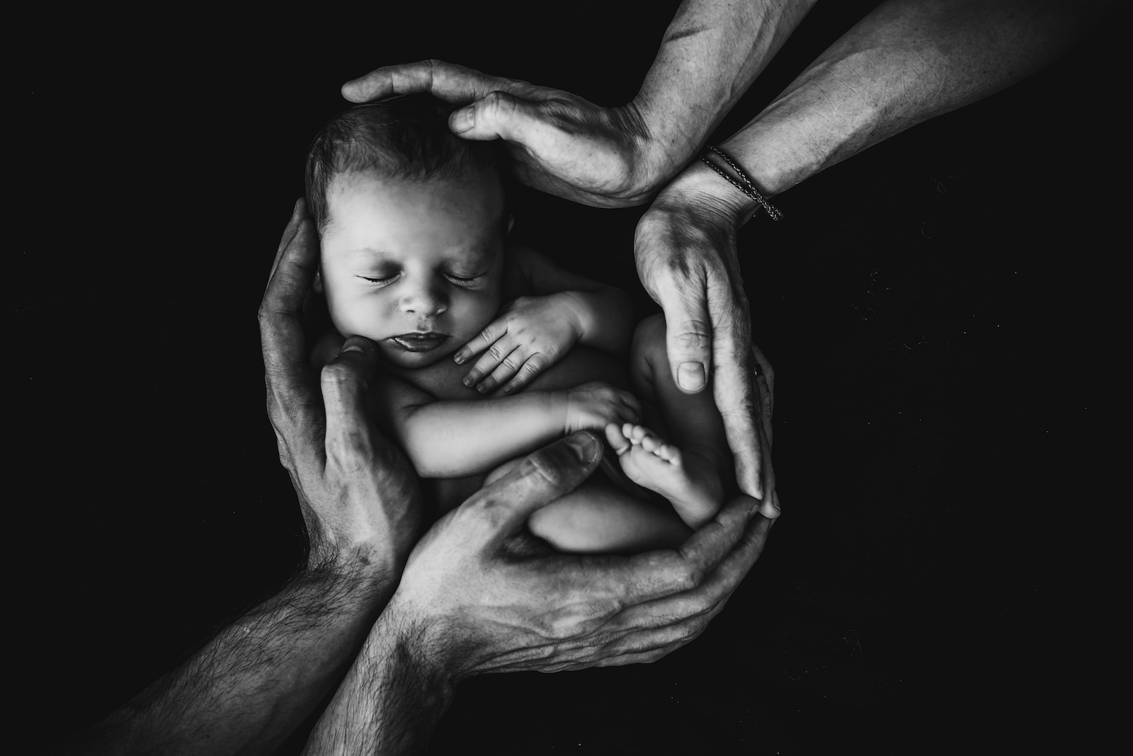 Grayscale photo of woman hugging baby