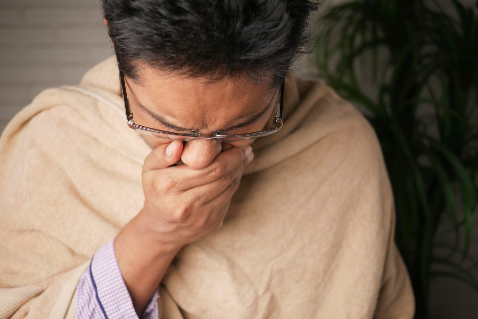 Man in brown sweater wearing black framed eyeglasses