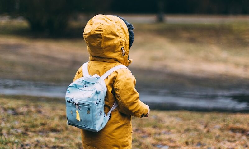 Shallow focus photo of toddler walking near river