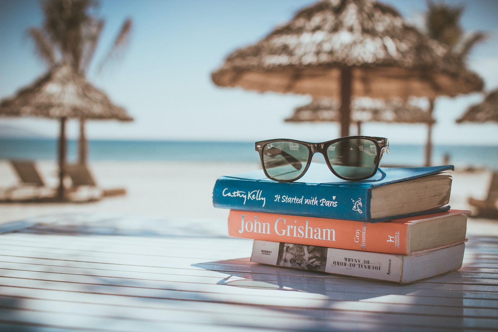 Black framed ray ban wayfarer sunglasses on top of book