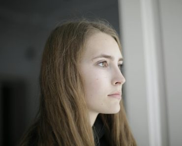 Pensive young woman in living room