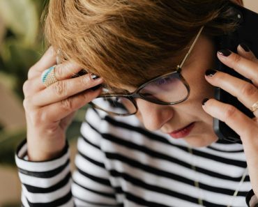 Anxious woman having phone conversation in office