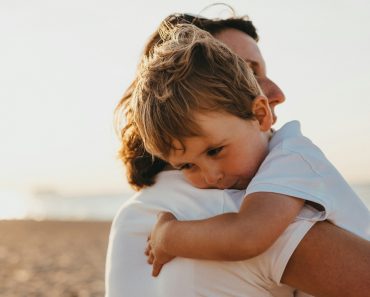 boy hugging woman during daytime