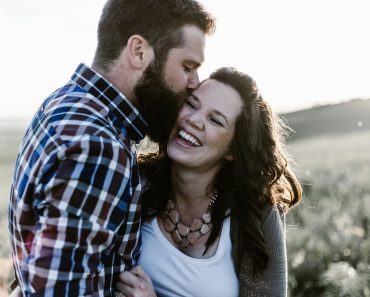 man kissing woman in grass area