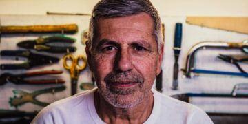Portrait Photo of Man in White Crew-neck T-Shirt With Assorted Hand Tools in Background