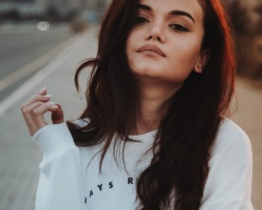 woman in white sweater taking selfie