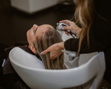 a woman getting her hair cut by a hair stylist