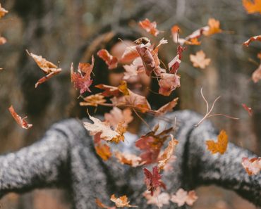 woman throwing maple leaves