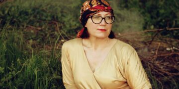 woman in brown long sleeve shirt wearing black and brown floral bandana