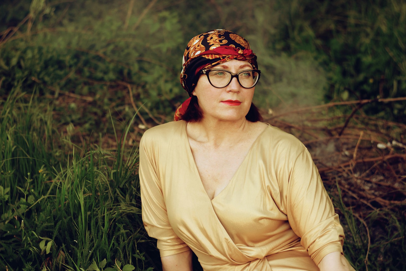 Woman in brown long sleeve shirt wearing black and brown floral bandana