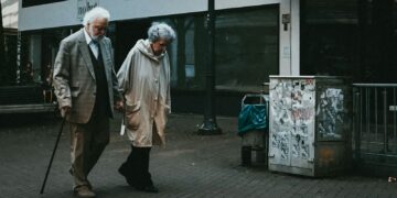 man in black suit standing beside woman in white coat