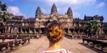 woman wearing red and white striped blouse standing in front of temple