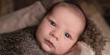 baby in brown swaddle