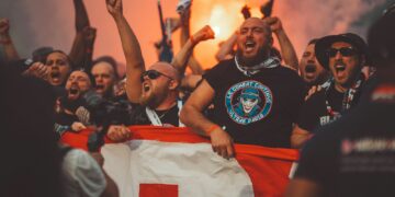 a group of people holding a flag and cheering