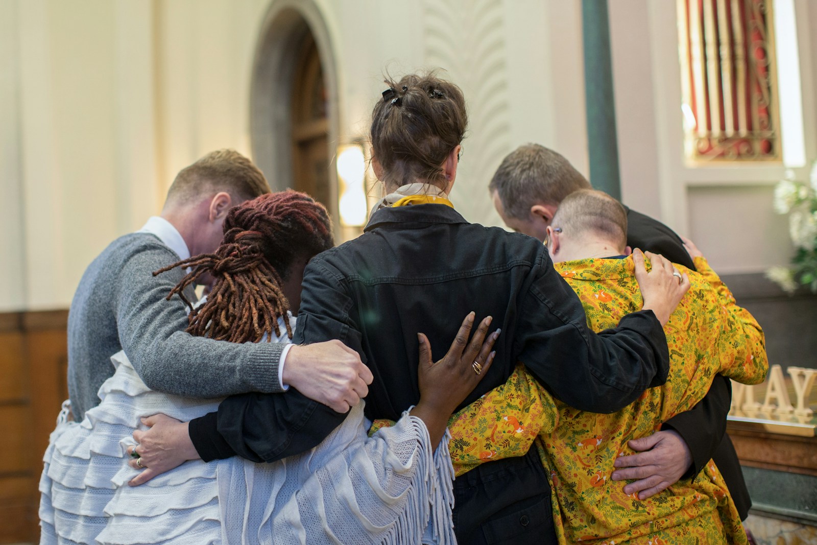 A group of people hugging each other in a church