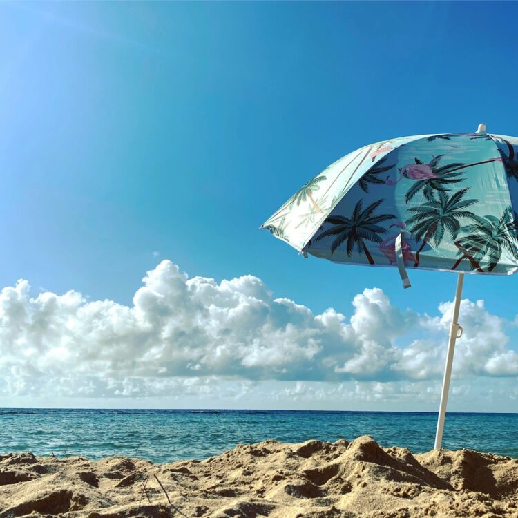 White and green umbrella on beach shore during daytime