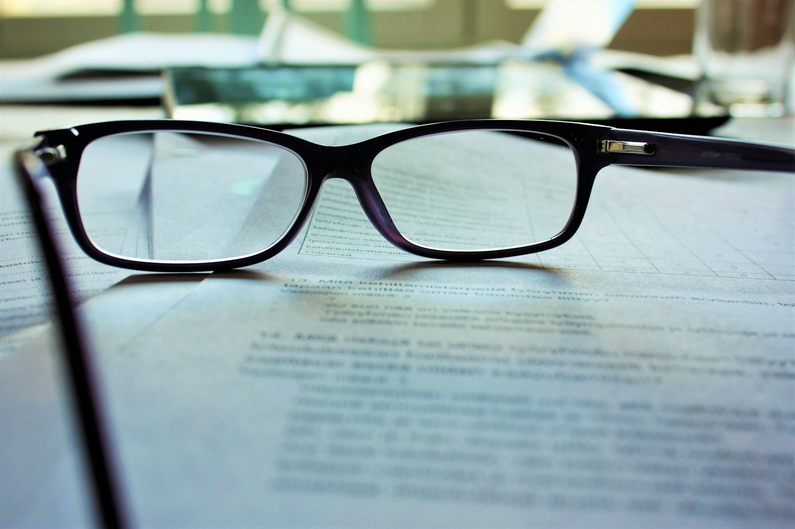 Black framed eyeglasses on white printing paper