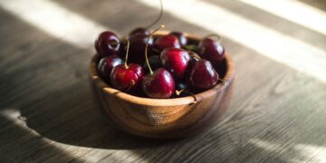 bunch of red cherries in brown bowl