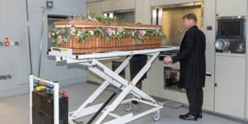 a man standing next to a table with a basket on it