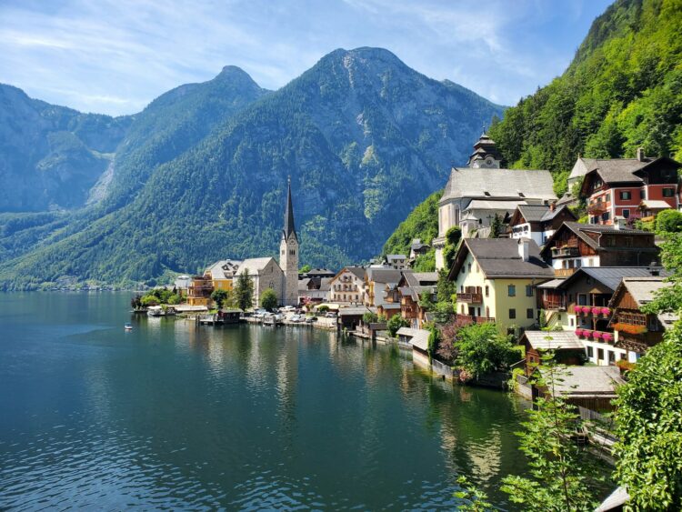 Houses near body of water and mountain during daytime