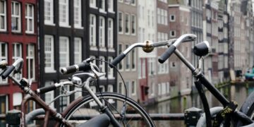 brown and black city bikes padlocked on black steel rail