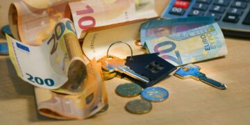 A pile of money sitting next to a calculator