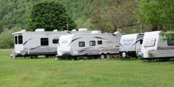 white and brown rv trailer on green grass field during daytime