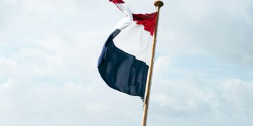 flag of us a on pole under white clouds