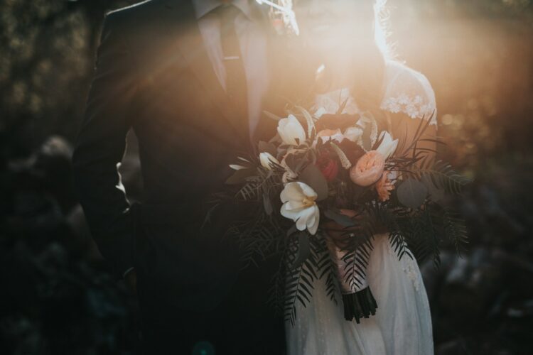 Groom beside bride holding bouquet flowers