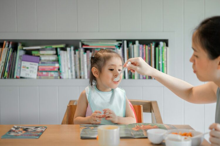 Woman holding white plastic spoon