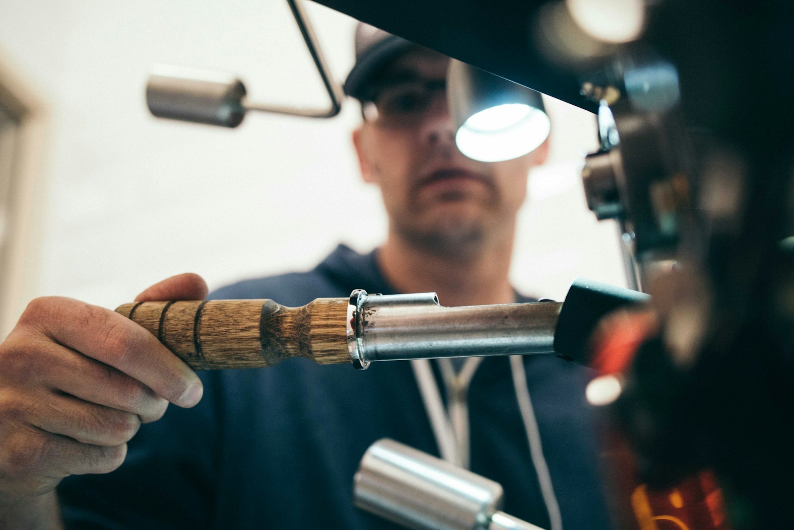 Man wearing black pullover hoodie holding tool