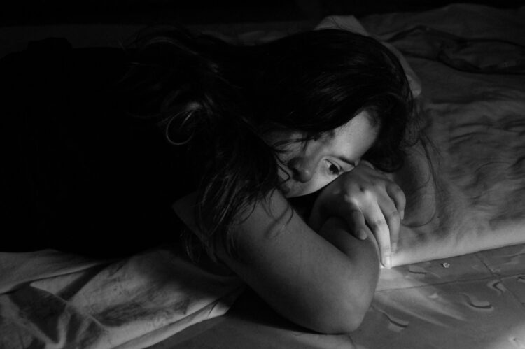 Woman leaning on bed