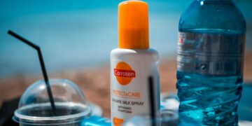 white and orange plastic bottle on blue table