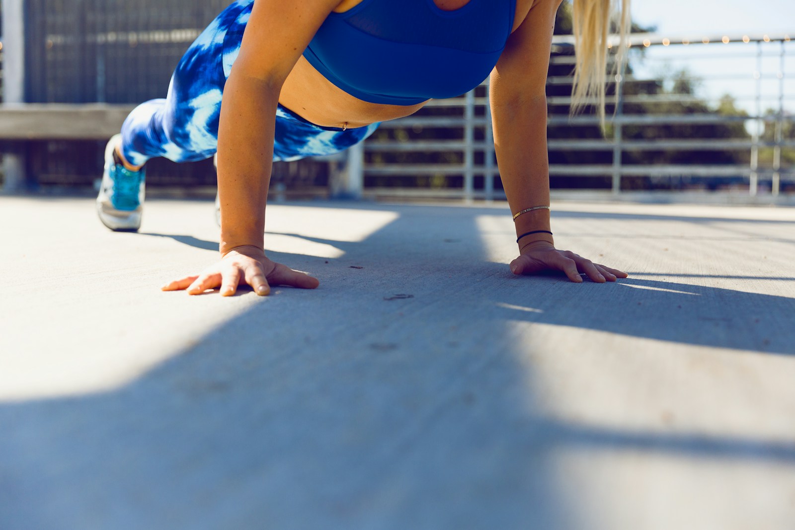 Woman planking on gray asphalt road