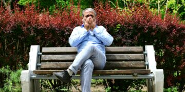 A man sitting on a bench in a park