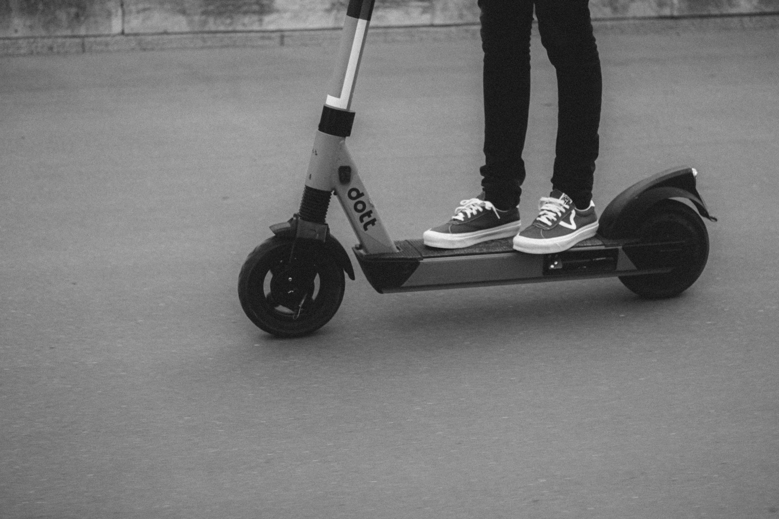 Person riding black and white kick scooter
