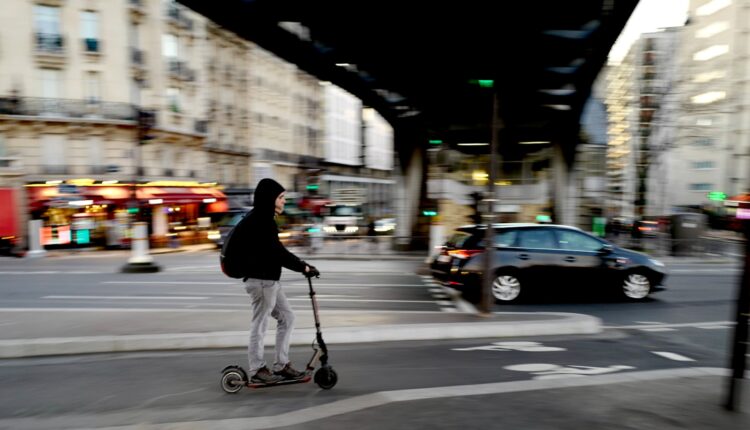 Man in black jacket riding on kick scooter on road during daytime