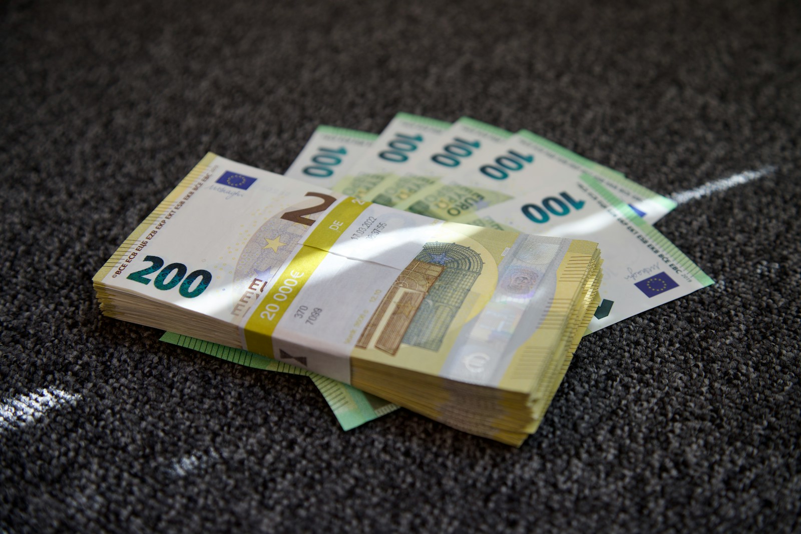 A pile of money sitting on top of a carpet