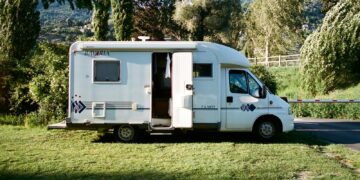 white and brown rv trailer on green grass field during daytime