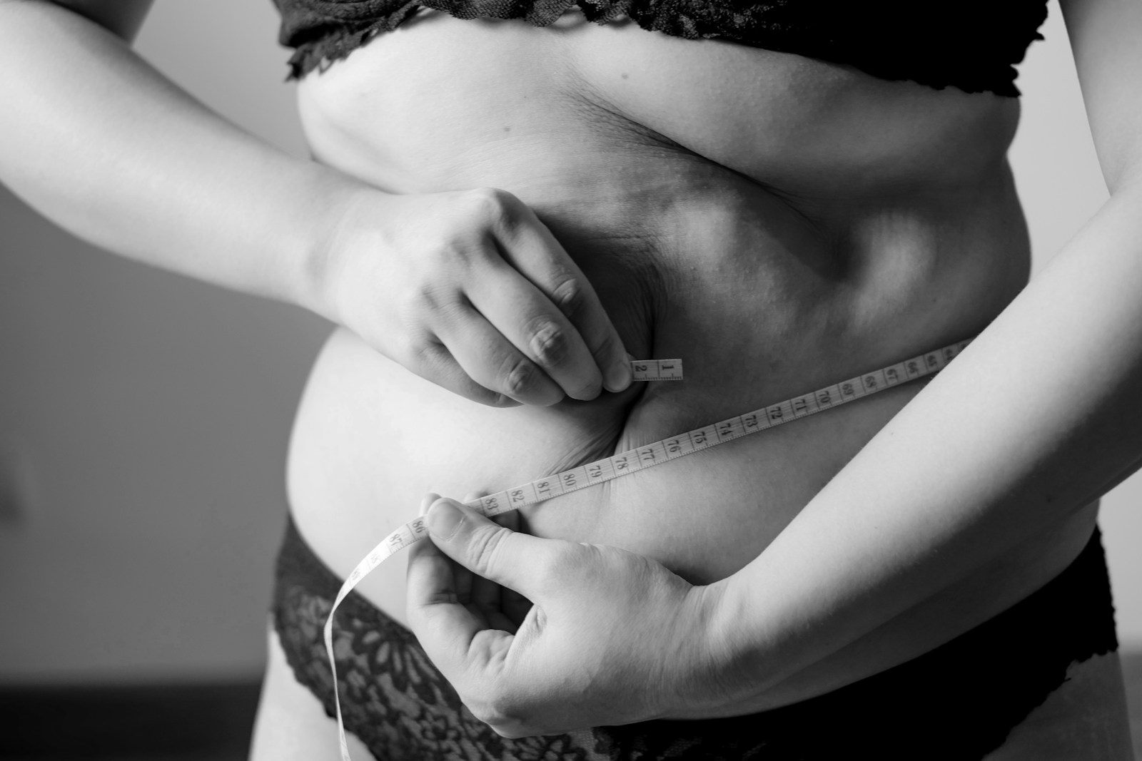 Grayscale photo of woman holding her breast