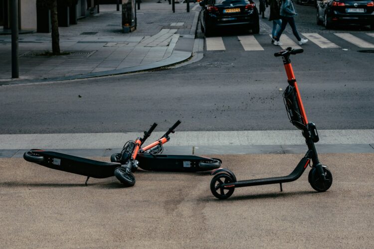 Motorized scooters parked near road during daytime