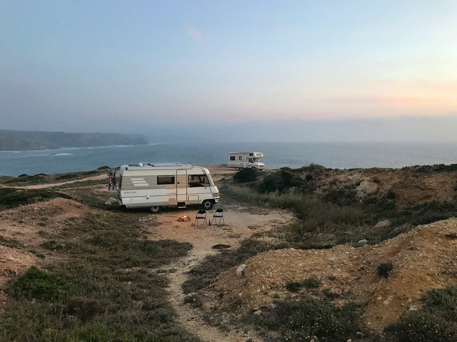 White and brown rv on brown field under blue sky during daytime