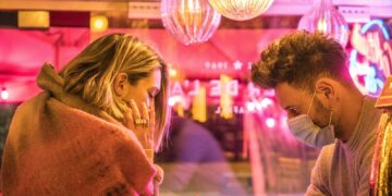 woman in white long sleeve shirt holding smartphone