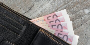 a wallet with a bunch of money sticking out of it