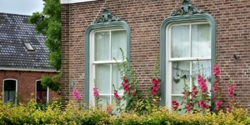 Windows with flowers decorate a brick building's facade.