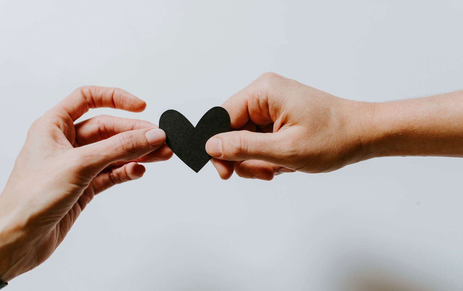 Two person holding papercut heart