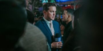 man in black suit standing in front of man in black suit