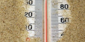 A close up of a thermometer in the sand